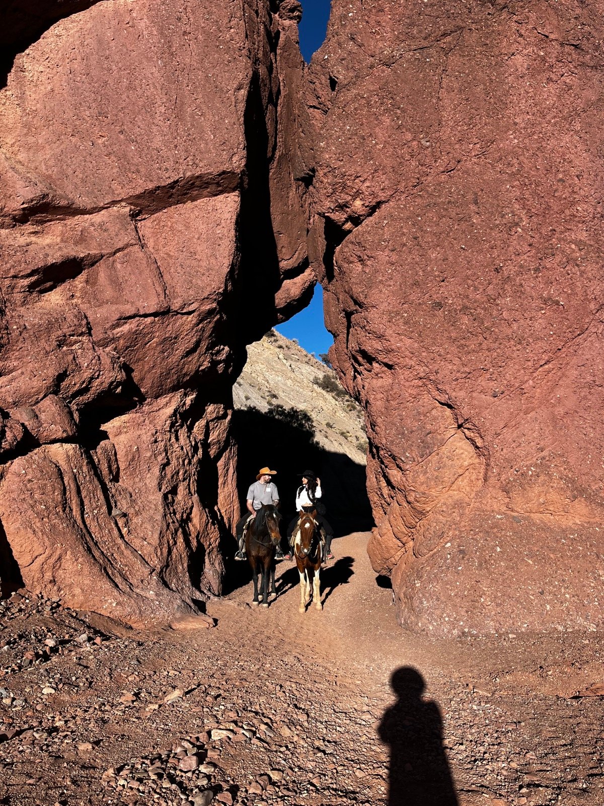 Jinetes atraviesan una abertura entre las rocas rojas de Tupiza